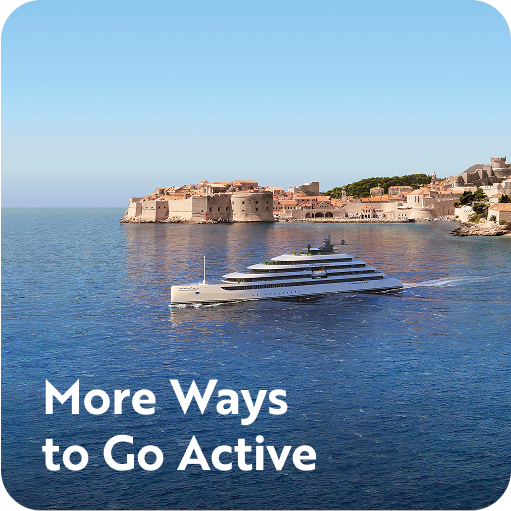 Yacht in the middle of the ocean, with a town in the distance