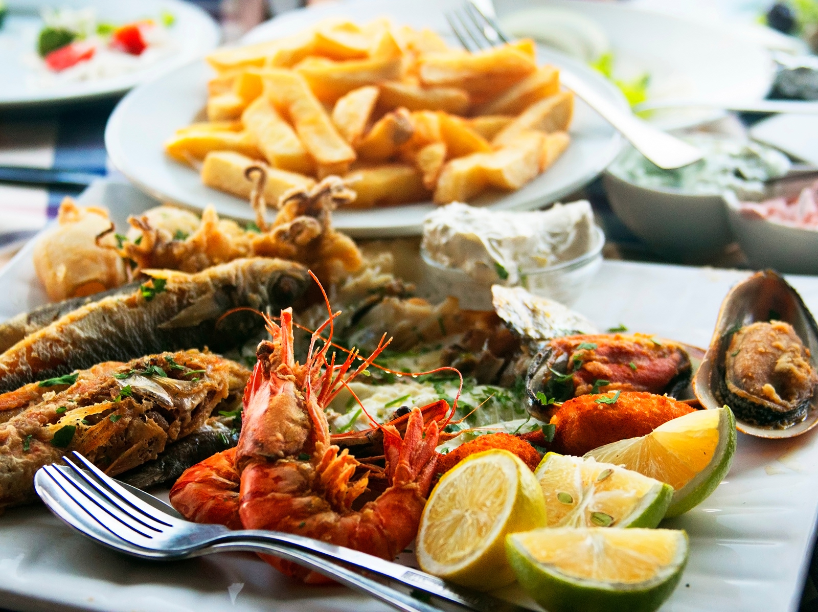 Plate of boiled seafood and a plate of french fries