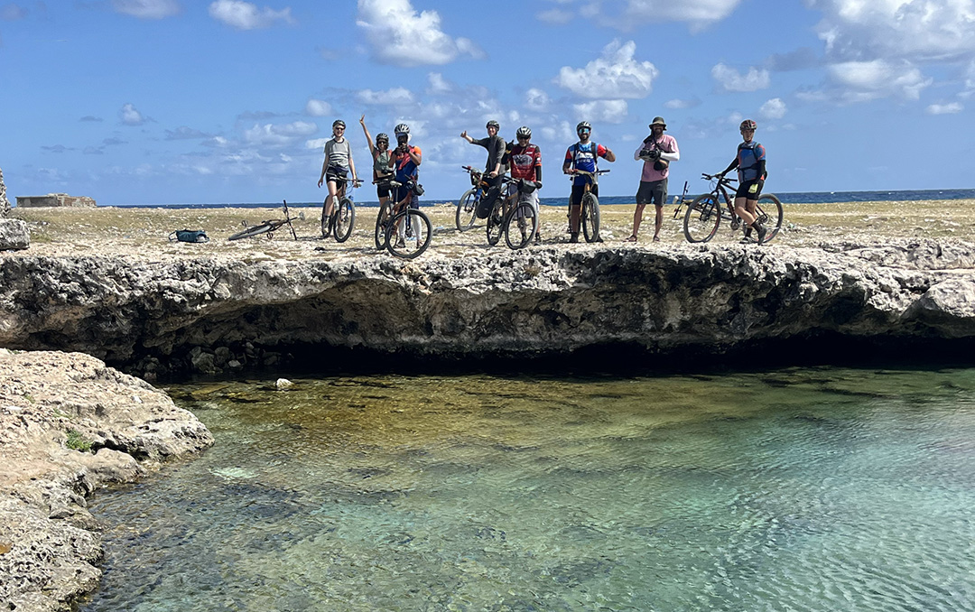 Group of bikers standing with their bikes on a cliff