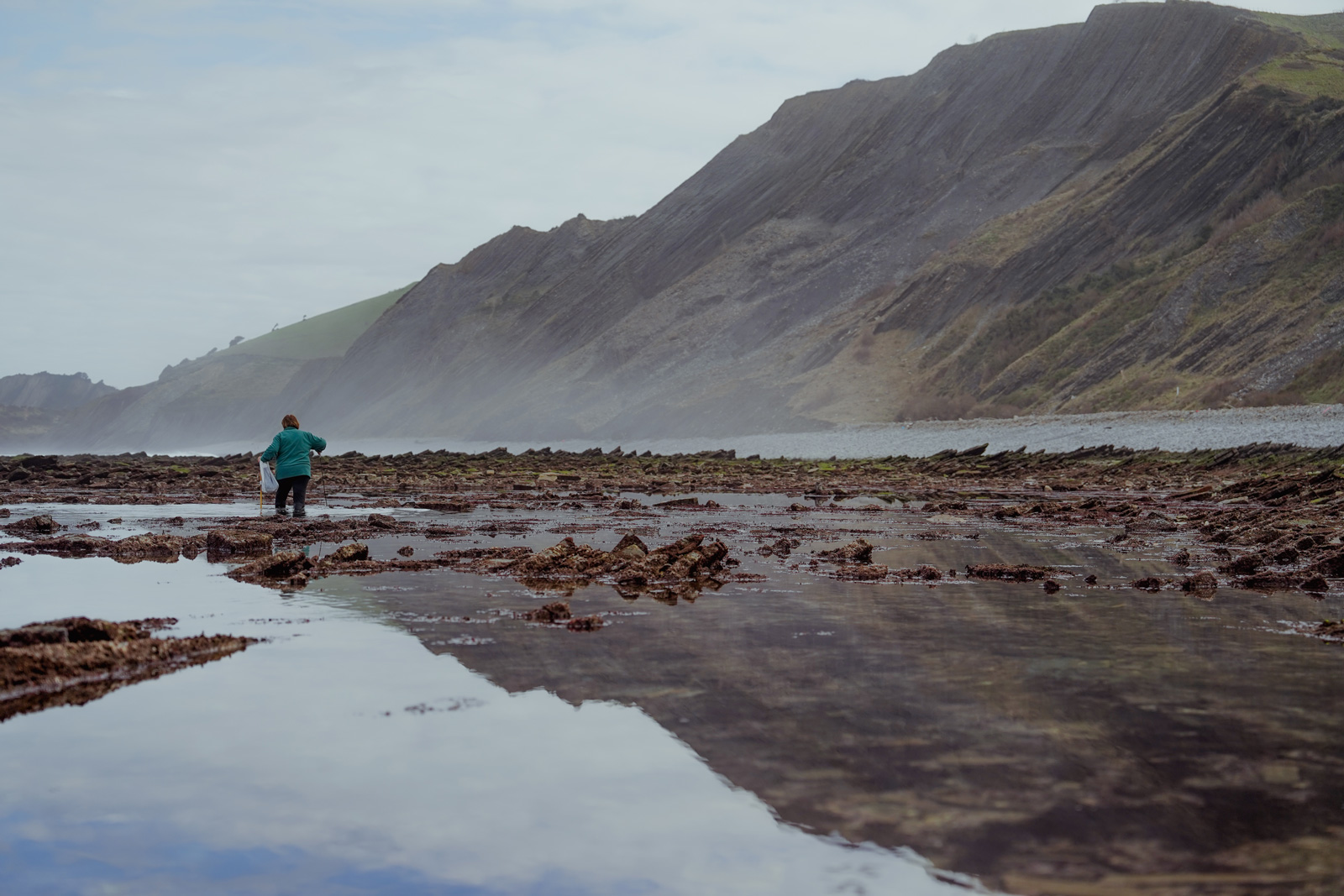 Woman walking through a rocky trail submerged in water