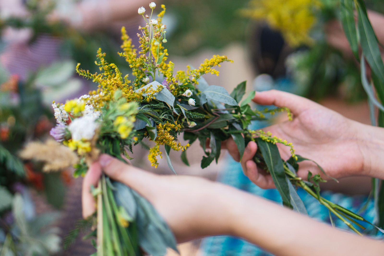 Person holding a bundle of flowers and plants