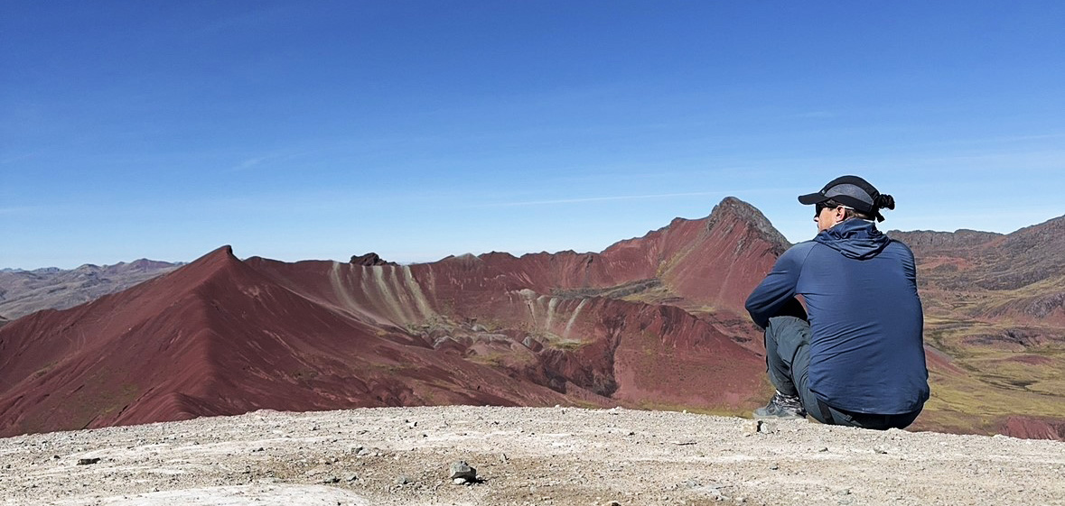 Backroads leader sitting on a hill admiring the landscape