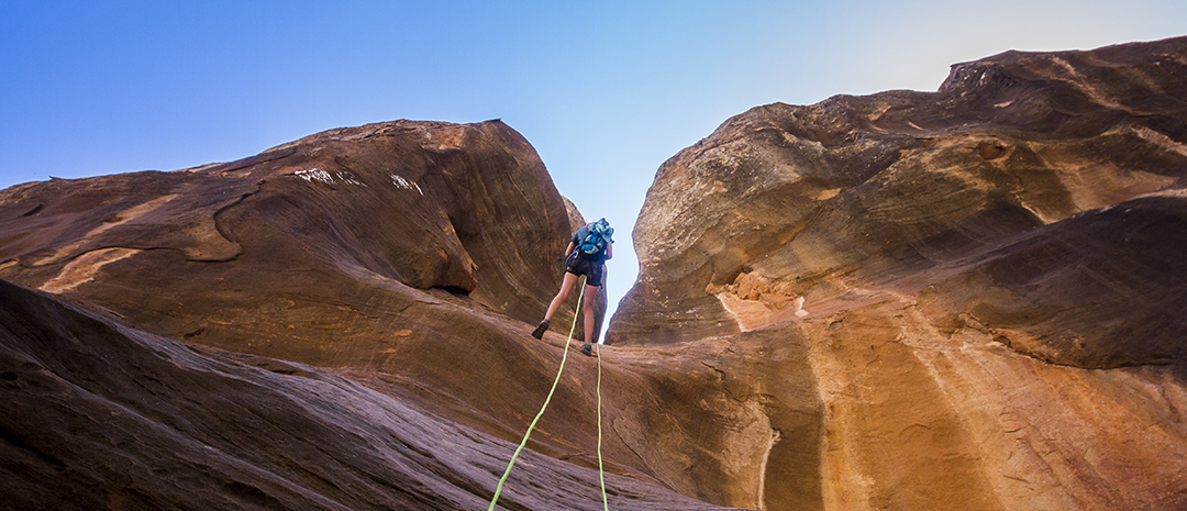 Person hiking up an orange canyon
