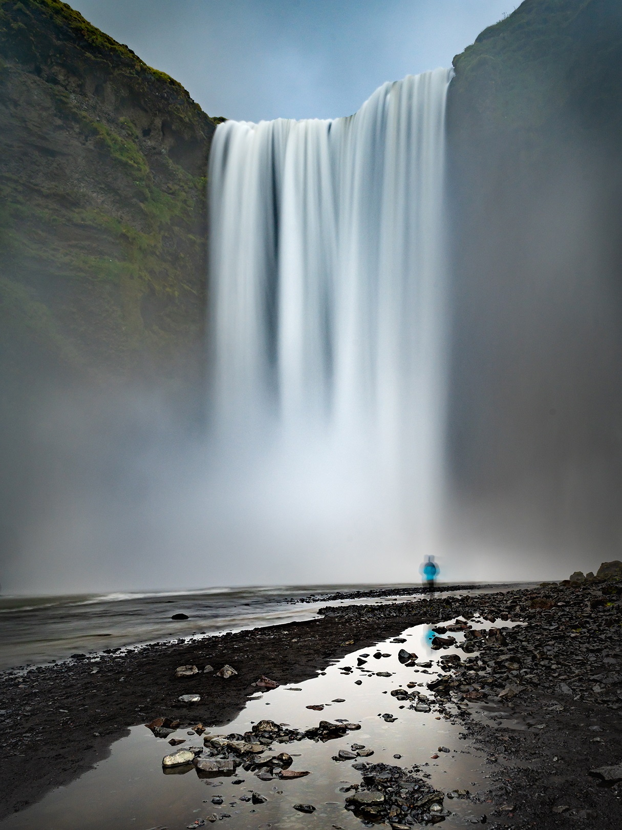 Large waterfall with a person looking at it from a distance
