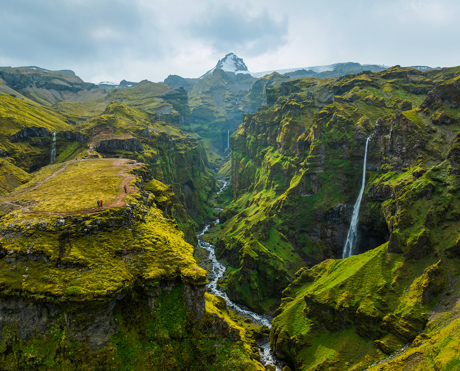 Tall mountains covered in grass and moss, with small waterfalls coming out