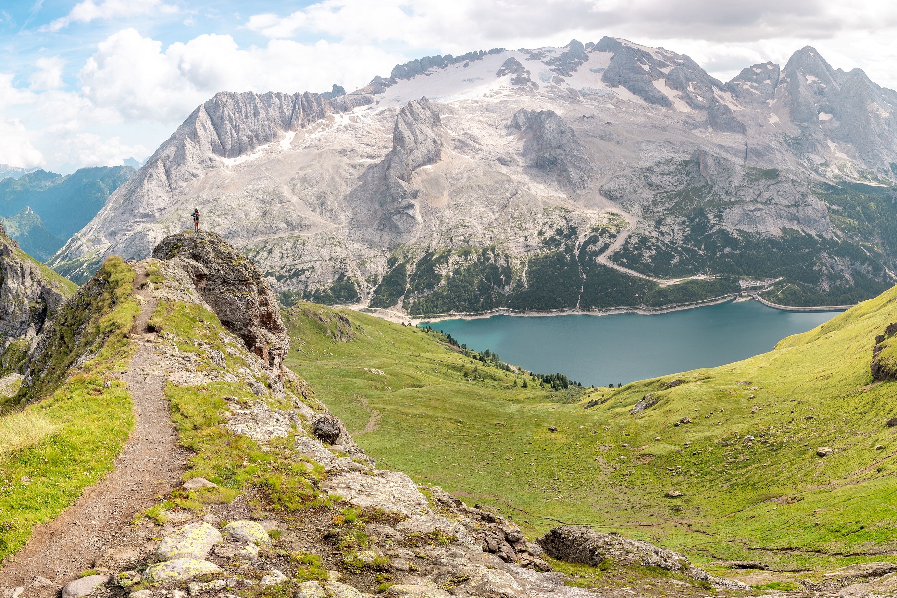 Grassy cliffs with a large lake and mountains in the background