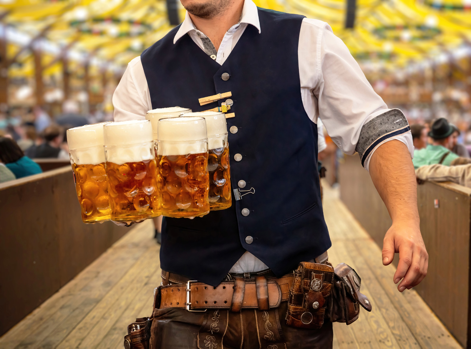 Man holding multiple mugs of beer