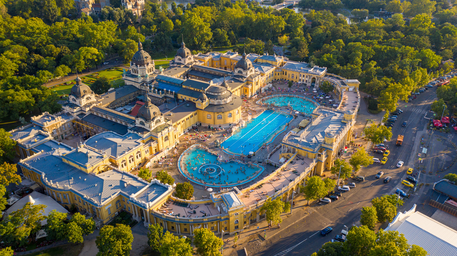 Sky view of large, castle-like building with a large outdoor pool