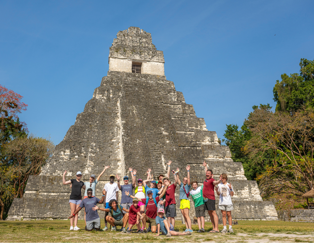 Group of people standing in front of a large pyramid