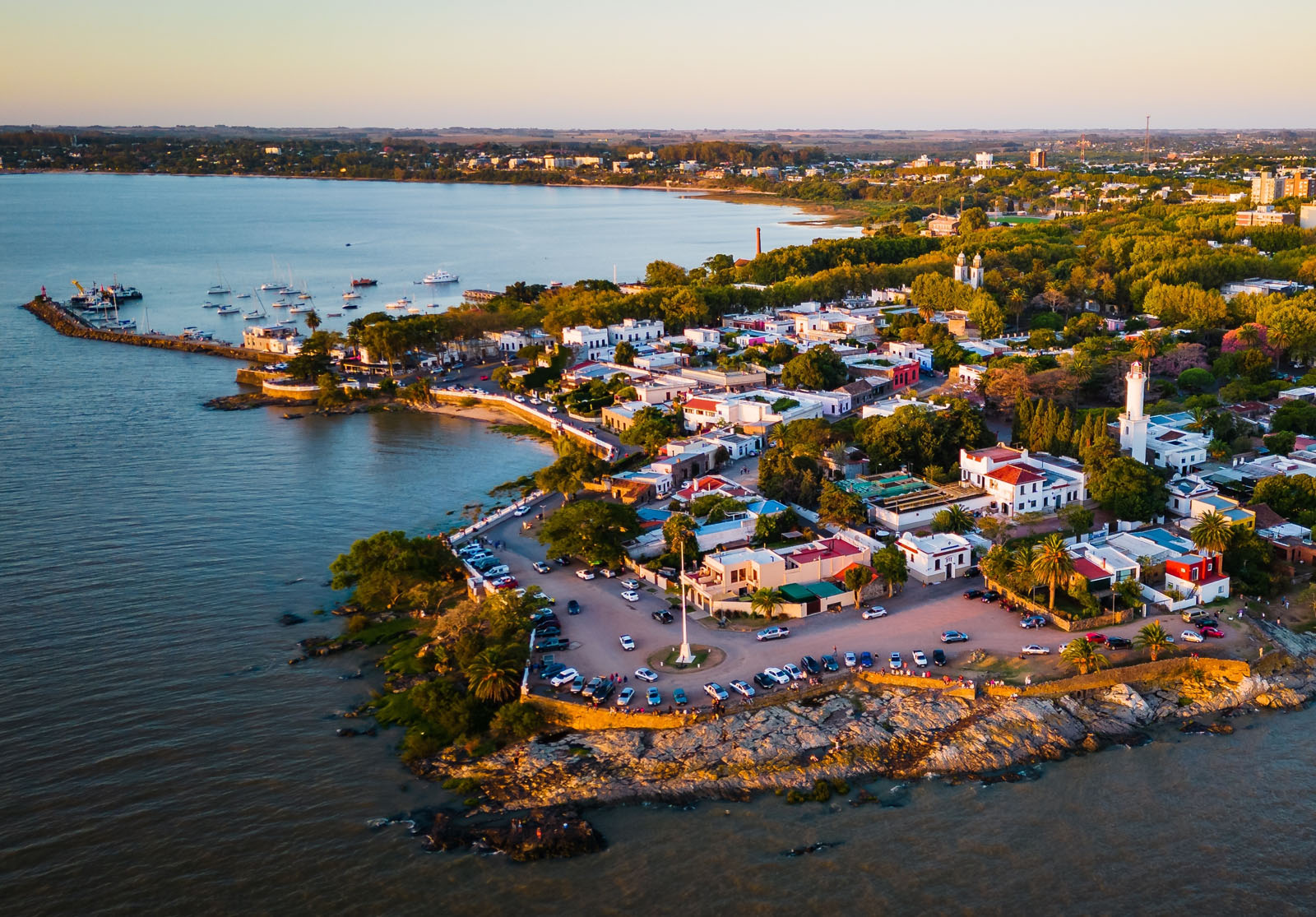 Sky view of small town by the ocean, with cars parked along the beach