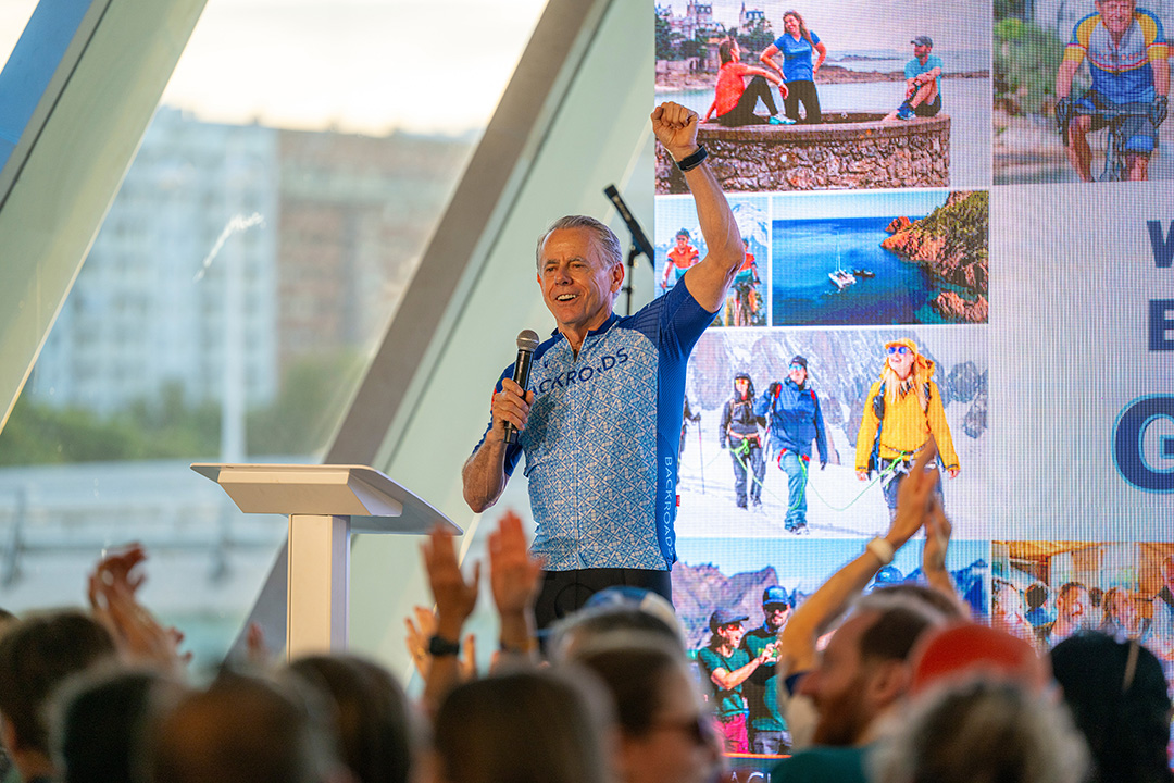 Man talking with a microphone to a group of people