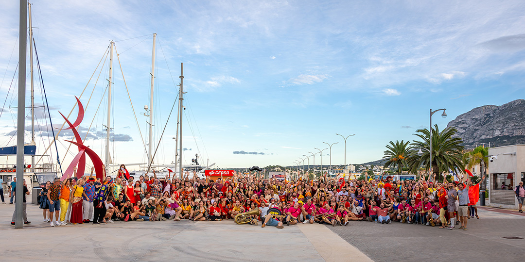 Large group of people by a boat port with blue skies in the distance