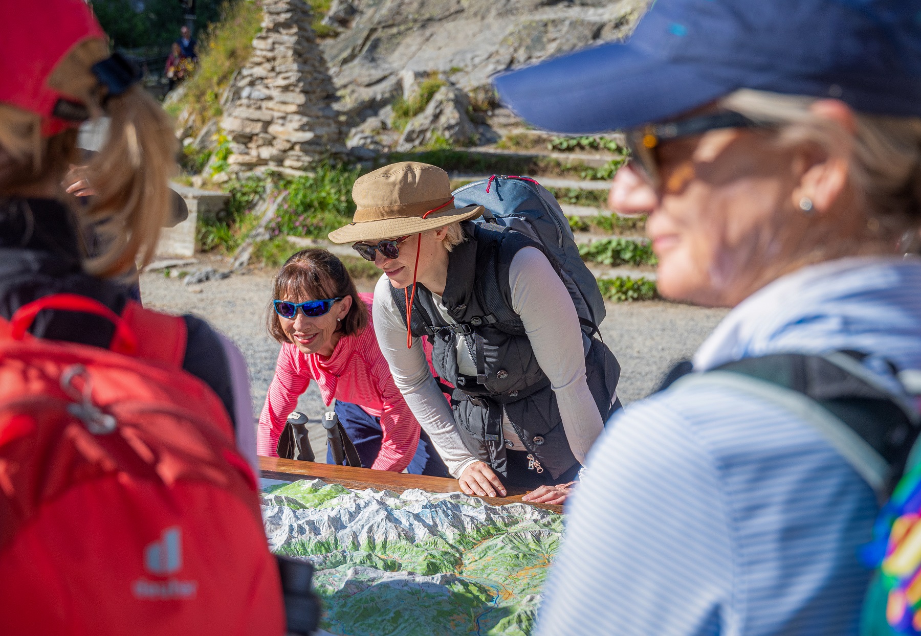 Group of women looking down at a 3D map of mountains