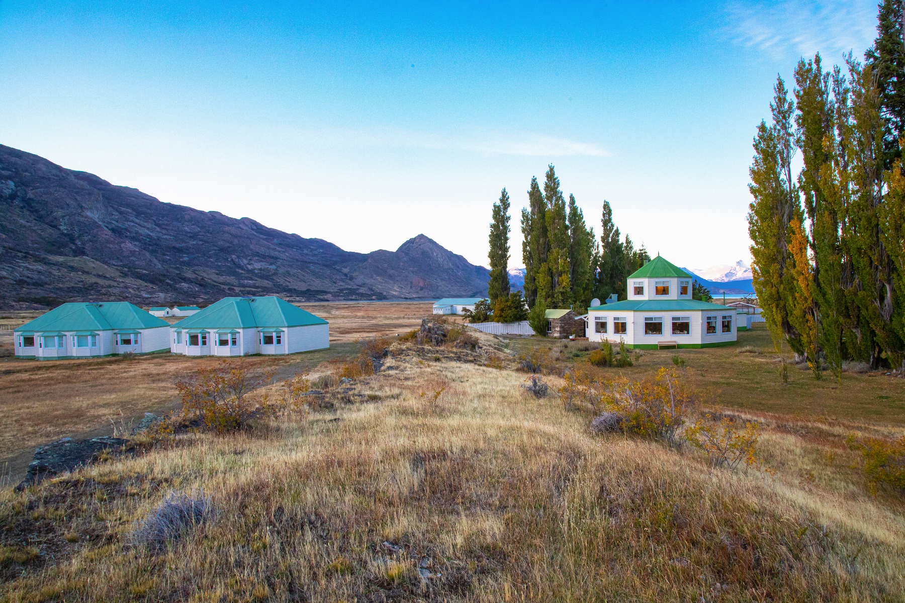 White houses with green roofing in an empty valley