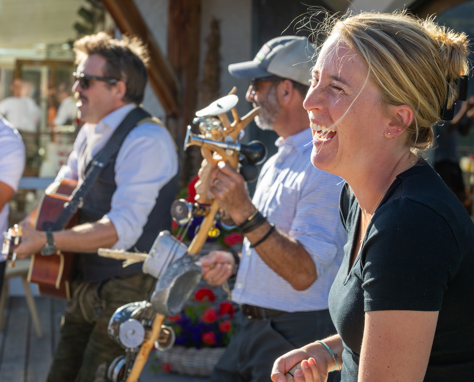 Woman smiling with a group of men playing instruments in the background