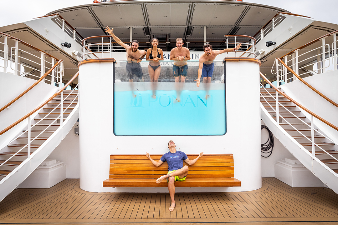 Group of people standing in a pool smiling
