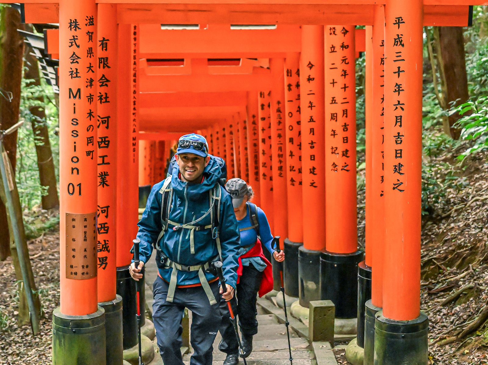 Man and woman smiling while walking along a Japanese shrine