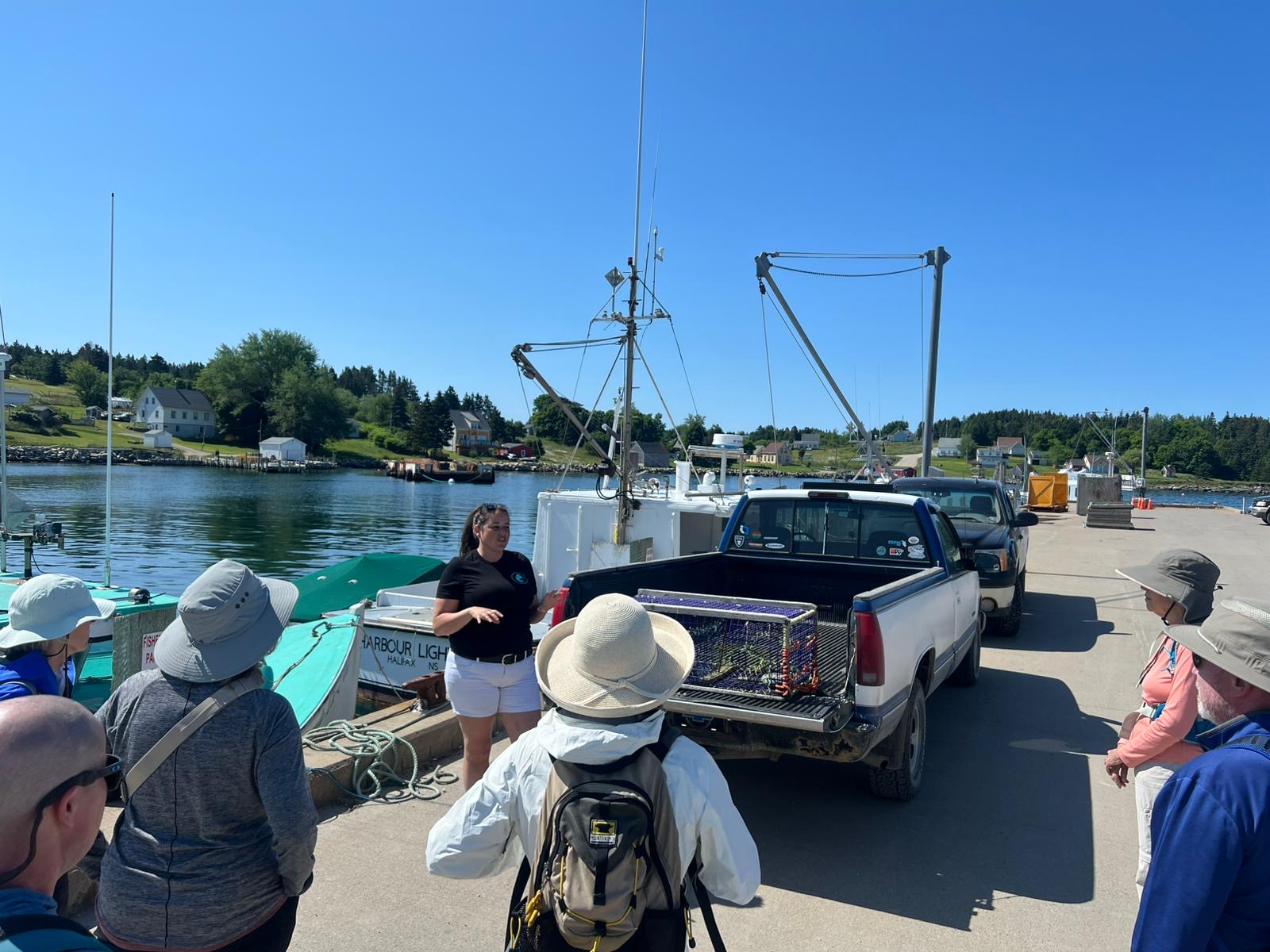 Group of people talking with a tour guide in front of a boat port