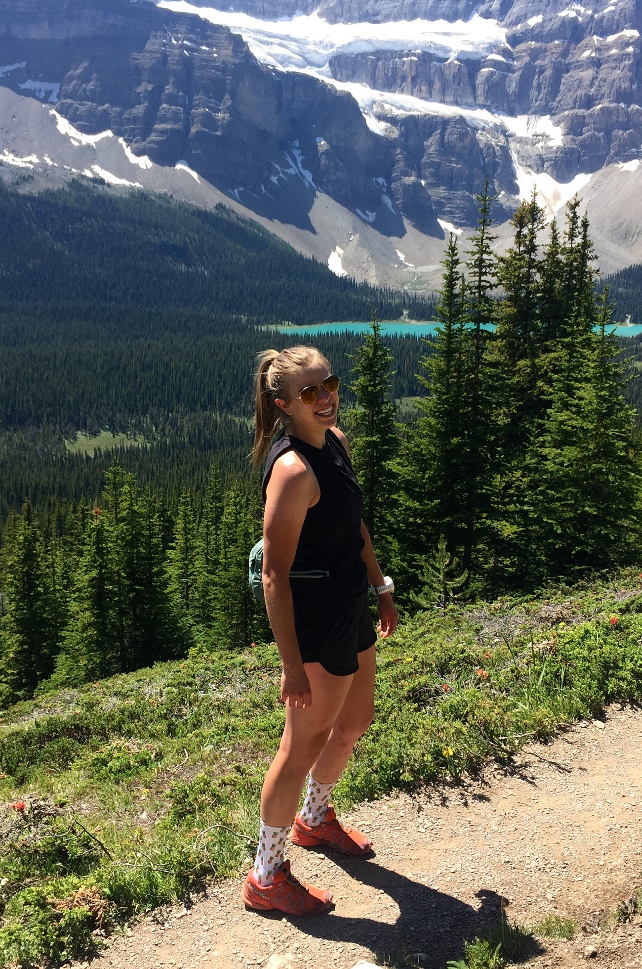 Woman standing on a dirt trail in the middle of a hill