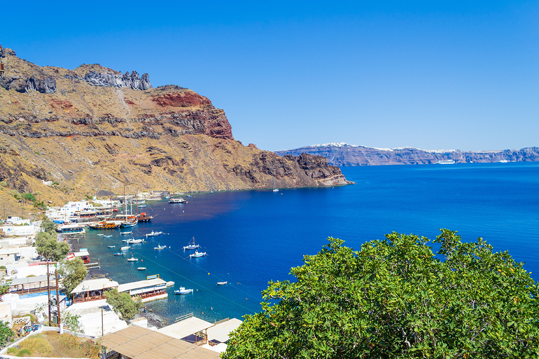 Blue ocean water with large cliffs in the background