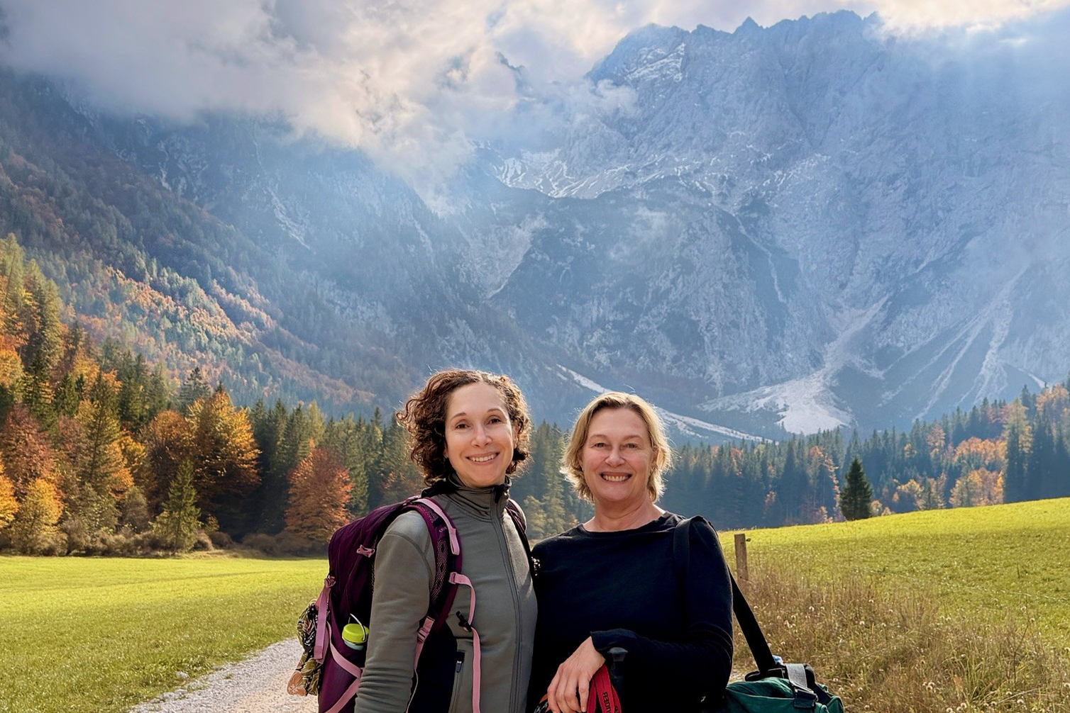 Two women smiling with views of large cliffs in the background