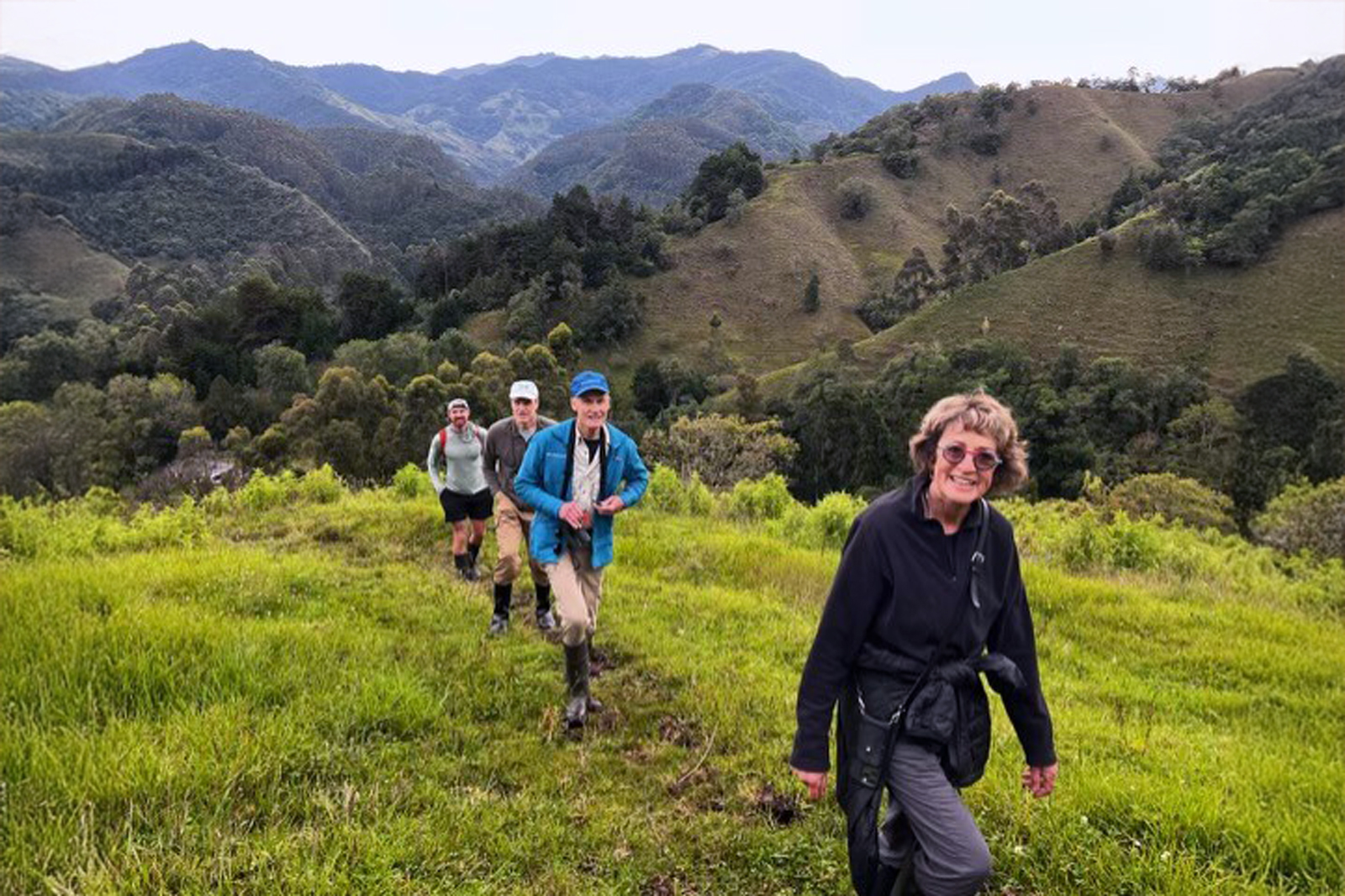 Group of people hiking on a grassy field