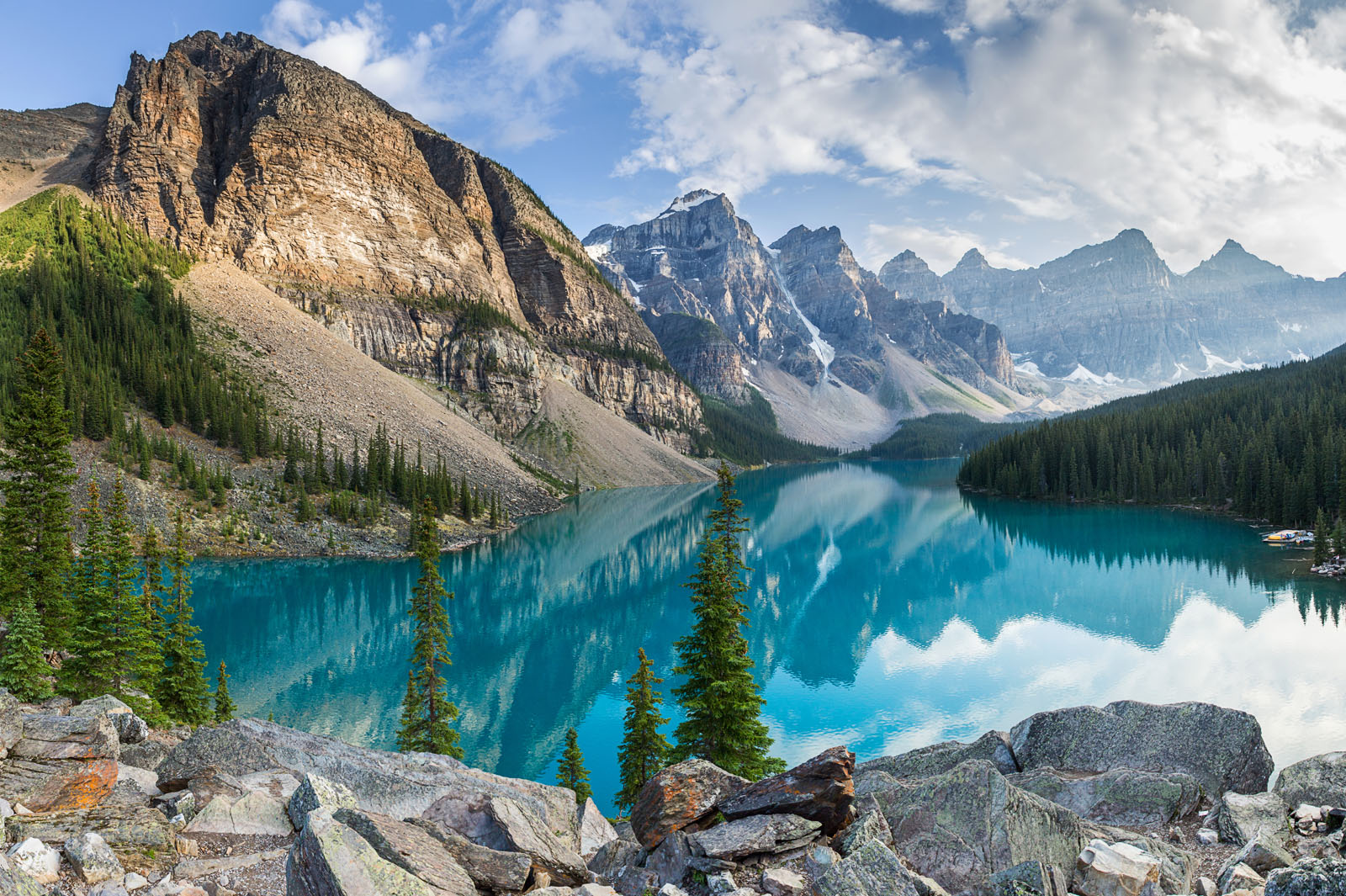 Large lake surrounded by large boulders and mountains in the background