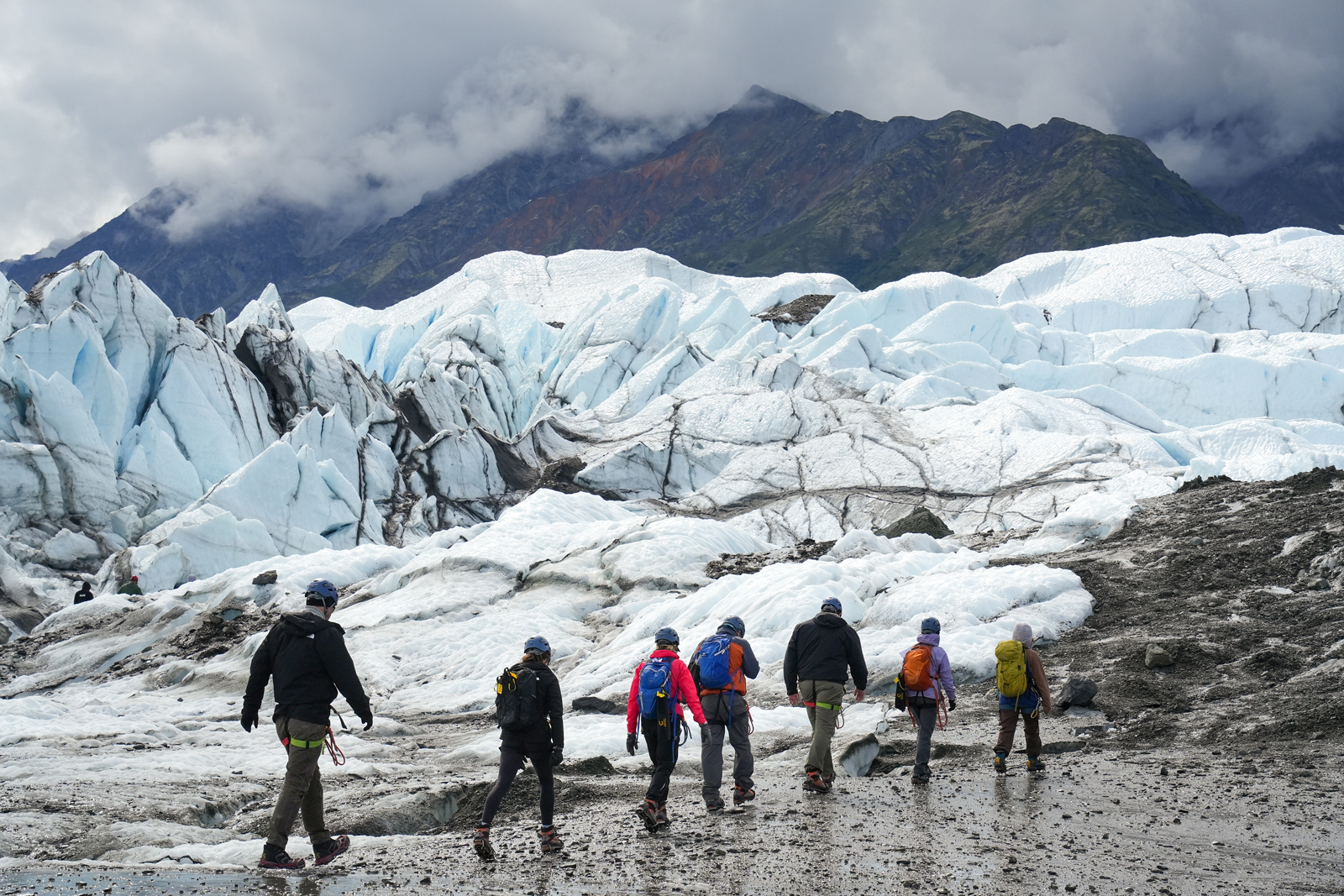 Hikers next to glacier in Alaska
