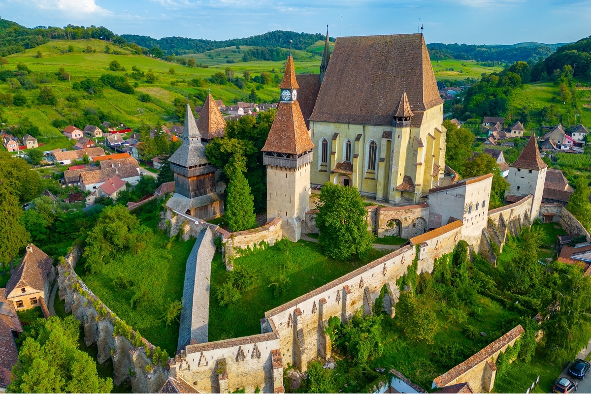 Exterior view of castle-like building with large grass fields and trees