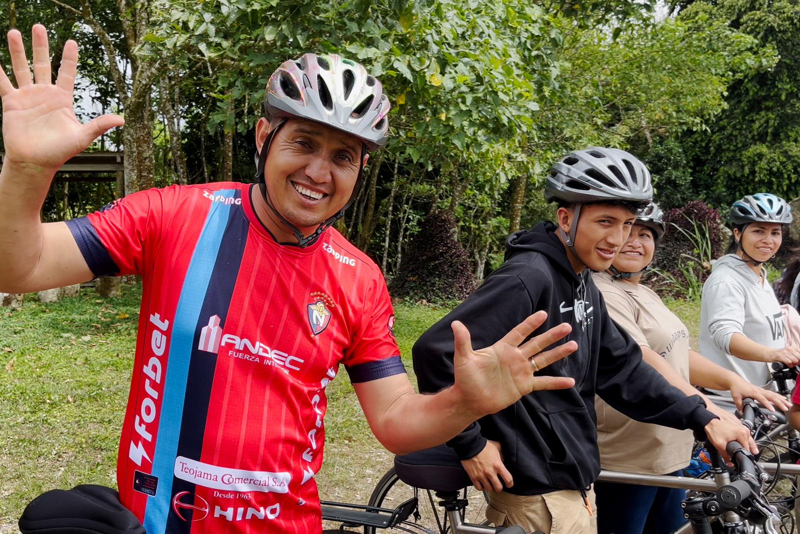 Group of people wearing helmets while smiling with their arms open
