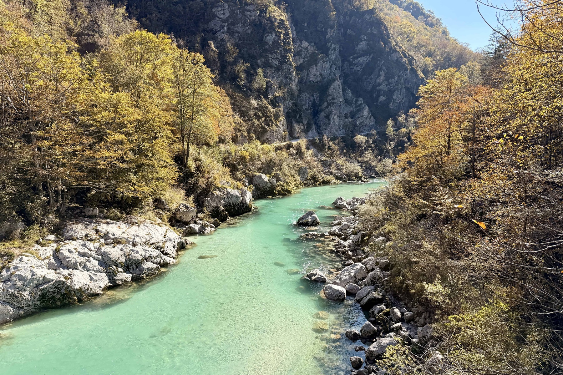 River surrounded by large boulders and tall mountains