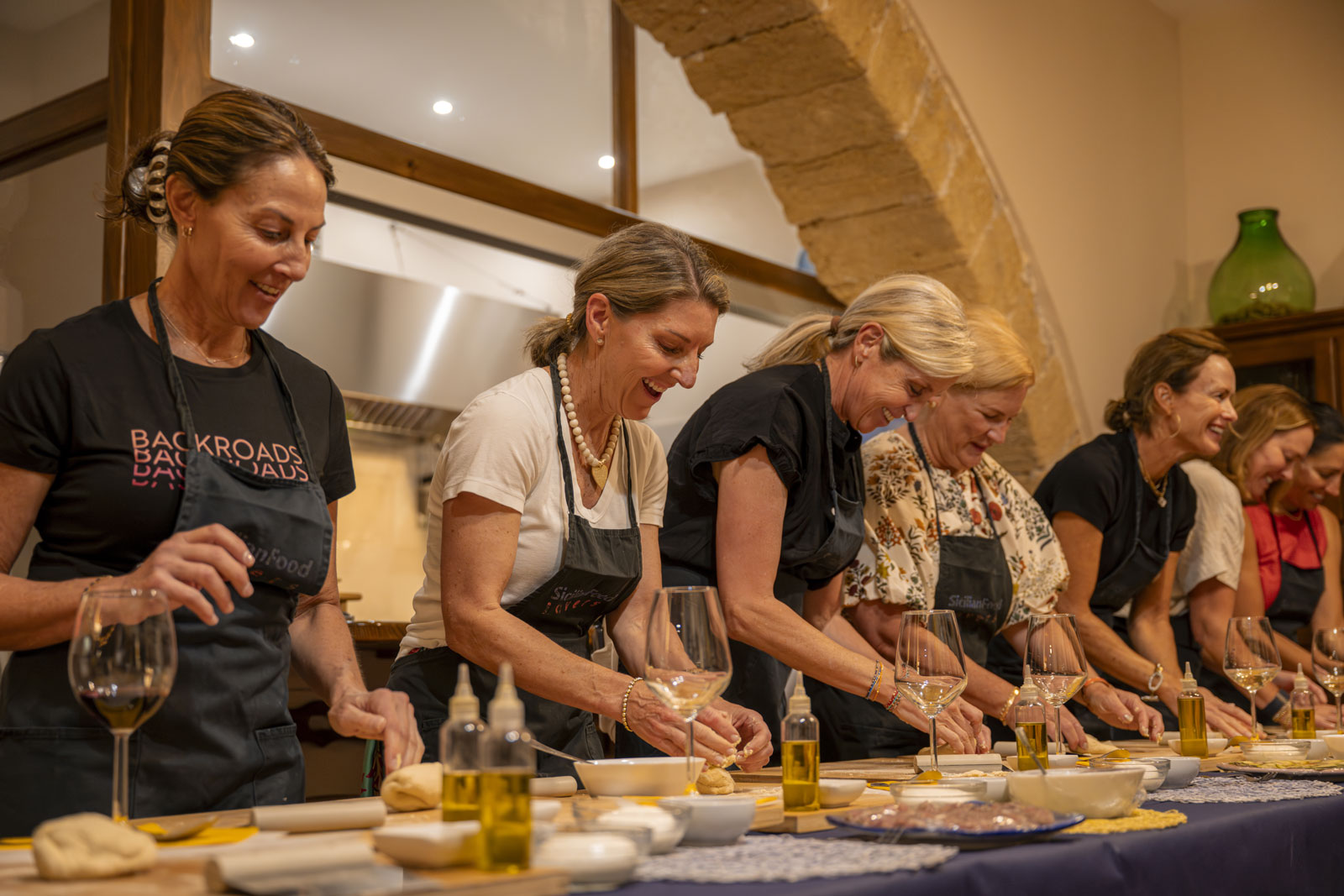 Group of people taking a cooking class, preparing plates of food