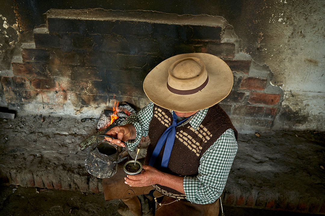 Man pouring drink into a mate cup