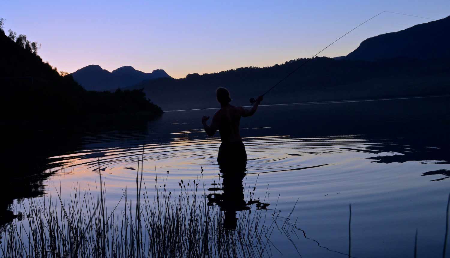 An angler casts to rising trout during the dwindling twilight hours of Patagonia.
