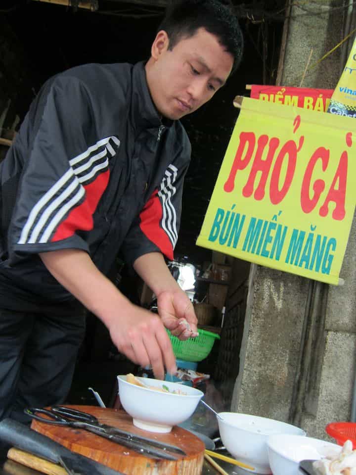 Preparing pho ga at a street-side noodle stand in Hanoi, Vietnam