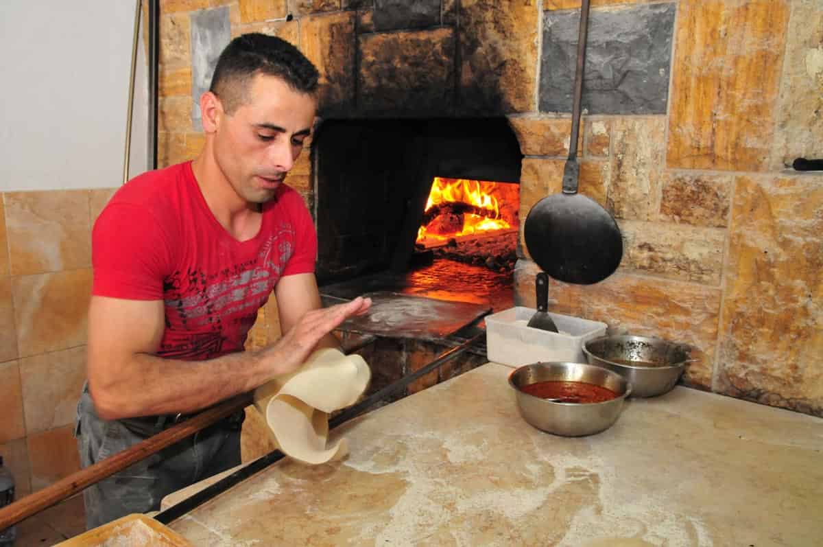 Israel, Mount Carmel, Isfiya (also known as Ussefiya, a Druze village and local council) A Druze Baker baking Pita