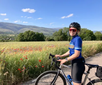 Image of a trip prep specialist on a bike in front of a field of poppies.