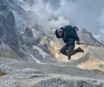 Image of a trip prep specialist jumping in front of an alpine scene.