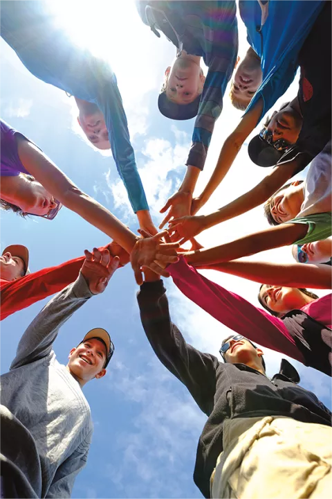 Group of people putting their hands in the middle