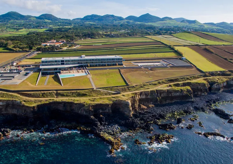 aerial view of hotel surrounded by fields on a cliffside