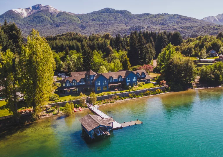 Sky view of blue lodge with a small pier and a large lake in the front