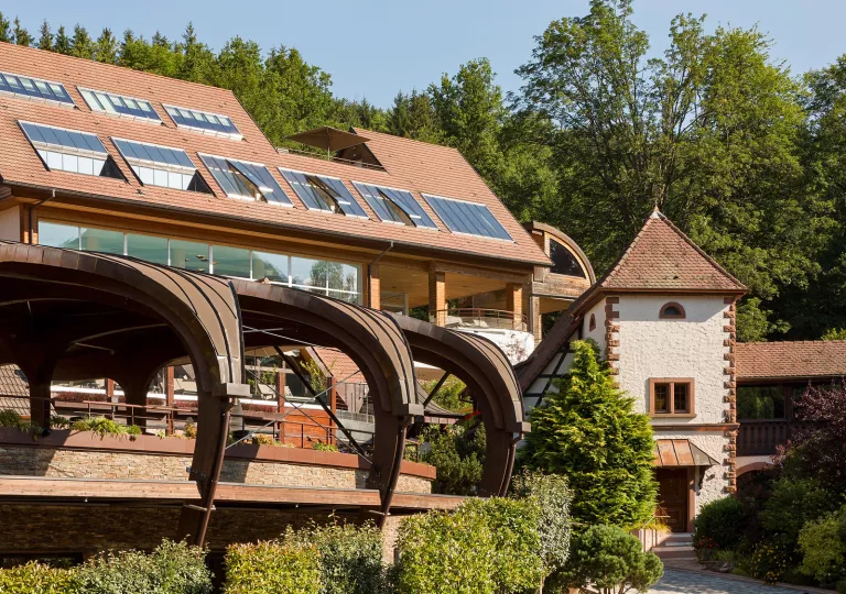 Exterior view of a brown building with large windows and curved archways