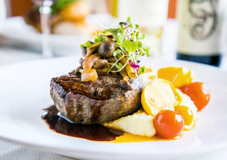 Plate of steak with mushrooms and vegetables on the side