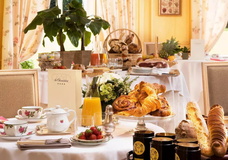 Dining tables with plates of pastries, fruit and glasses