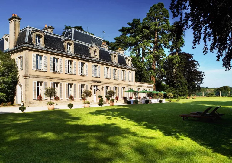 Yellow hotel building with large grass area in front