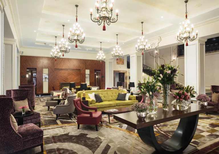 Indoor hotel lobby with candle chandeliers and cushioned sofas