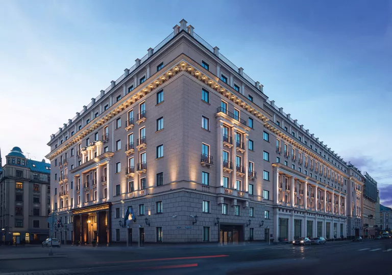 Outdoor view of hotel building with lots of windows, illuminated by orange lights along the walls