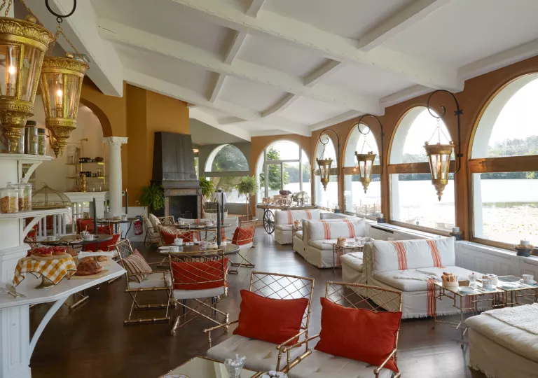 large living room with couches and fireplace and large bay windows