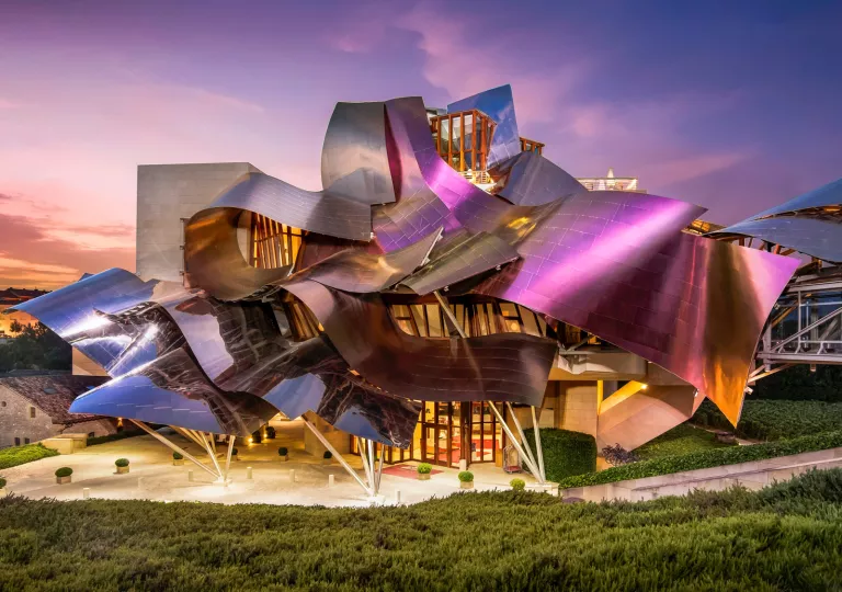 Building with foil-like roofing, surrounded by tall bushes