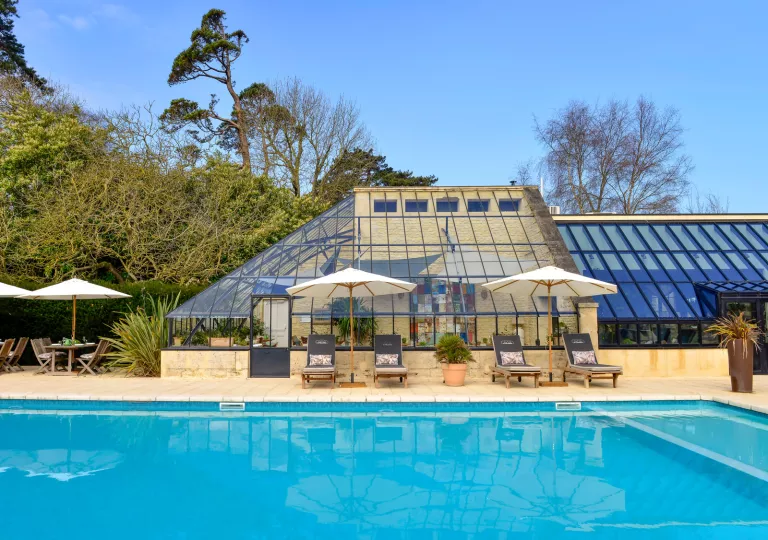 Outdoor pool next to a building with a glass roof